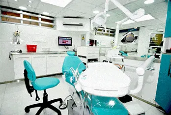 Consultorio 1 con sillón dental turquesa y lámpara