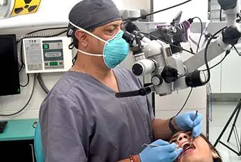 Odontólogo revisando a una paciente a través del microscopio dental