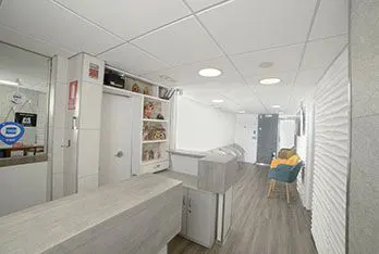 Recepción de la clínica con mostrador claro y piso de madera